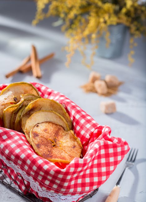 Cinnamon-dusted apple crisps in a rustic basket, perfect for a cozy snack.
