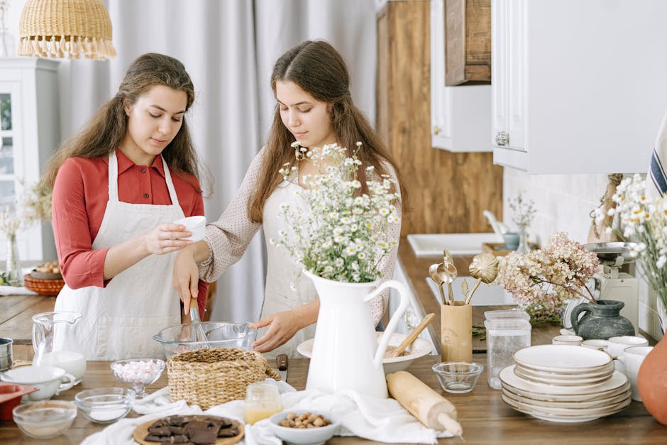 Two women baking together in a cozy kitchen setting, surrounded by ingredients and tools.