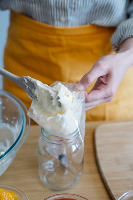 Close-up of person preparing whipped cream in a kitchen setting.